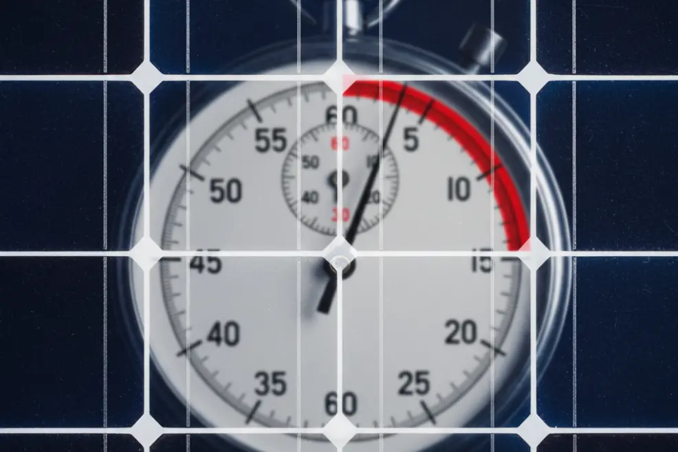 Close-up image of a stopwatch reflected on a solar panel.